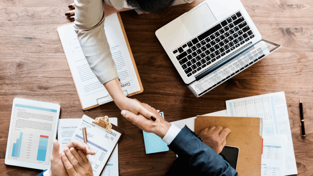 Three people working together and shaking hands, representing one vision, three allies.